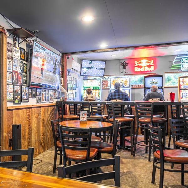 Diners seated at high-top tables and bar stools, watching sports and playing video lottery at Dea's In & Out.